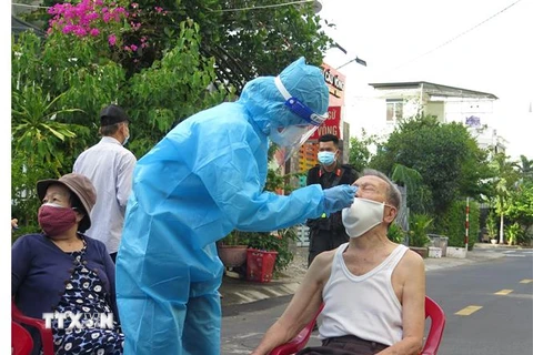 Cán bộ y tế tiến hành lấy mẫu gộp 3 người trong hộ gia đình để tầm soát cộng đồng diện rộng tại thành phố Nha Trang. (Ảnh: Phan Sáu/TTXVN)