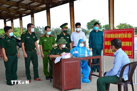 Chốt kiểm soát COVID-19 của Bộ đội Biên phòng tỉnh Nam Định tiến hành khai báo y tế cho ngư dân trước khi cập cảng. (Ảnh: Công Luật/TTXVN)