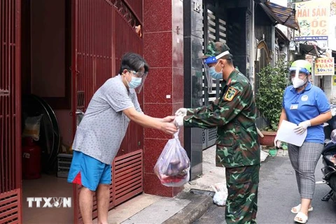 Cán bộ, chiên sỹ Sư đoàn 309 vận chuyển quà tặng nhu yếu phẩm sinh hoạt đến cho người dân tại phường 6, quận Tân Bình. (Ảnh: Xuân Khu/TTXVN)