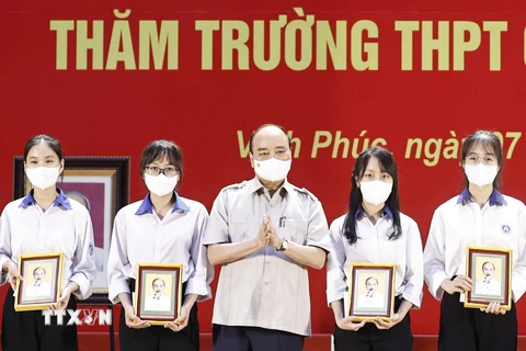 Chủ tịch nước Nguyễn Xuân Phúc tặng quà cho các học sinh đoạt giải cao qua các kỳ thi. (Ảnh: Thống Nhất/TTXVN)