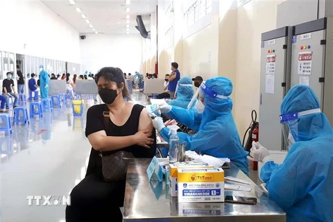 Các công nhân đang làm việc theo phương án "3 tại chỗ" tại Khu chế xuất Tân Thuận, Quận 7, Thành phố Hồ Chí Minh bắt đầu tiêm mũi vaccine thứ 2. (Ảnh: Thanh Vũ/TTXVN)