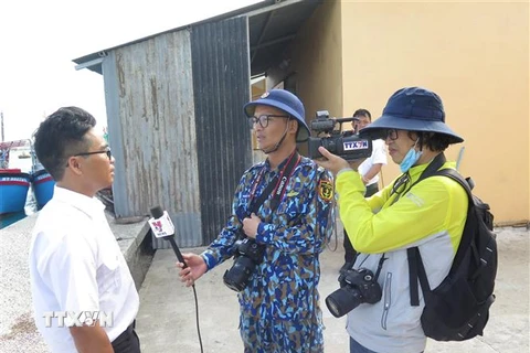 Nhóm phóng viên TTXVN và Báo Hải quân Việt Nam tác nghiệp về nội dung công ty hậu cần hỗ trợ các nhu yếu phẩm, vật liệu phục vụ cho ngư dân vươn khơi bám biển tại huyện đảo Trường Sa hồi tháng 5/2021. Ảnh: Phan Sáu -TTXVN