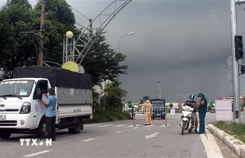 Lực lượng chức năng kiểm tra giấy đi đường của người dân tại chốt kiểm soát đại lộ Lê Lợi, thành phố Thanh Hóa. (Ảnh: Nguyễn Nam/TTXVN)