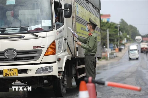 Lực lượng chức năng tại chốt kiểm soát đầu cầu Trung Hà (huyện Ba Vì, Hà Nội) kiểm tra giấy tờ của người và phương tiện khi qua chốt. (Ảnh: Minh Quyết/TTXVN)