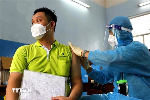 Các y bác sỹ bệnh viện Ung Bứu tiêm vaccine phòng COVID-19 cho công nhân viên chức lao động Tp. Hồ Chí Minh tại điểm trường THCS Lê Lợi, Quận 3. (Ảnh: Thanh Vũ/TTXVN)