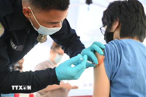 Nhân viên y tế tiêm chủng vaccine ngừa COVID-19 cho người dân tại Los Angeles, California, Mỹ. (Ảnh: AFP/TTXVN)