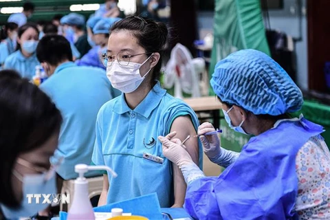 Nhân viên y tế tiêm vaccine ngừa COVID-19 cho các em học sinh tại một trường học ở Thẩm Dương, tỉnh Liêu Ninh (Trung Quốc), ngày 28/7. (Ảnh: AFP/TTXVN)