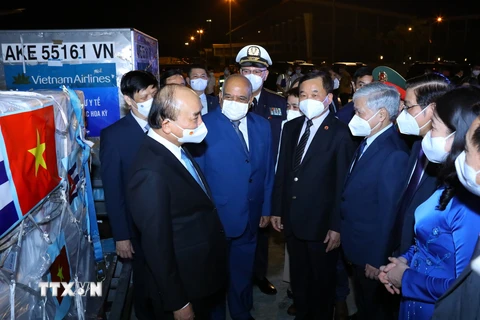 Chủ tịch nước Nguyễn Xuân Phúc với các đại biểu tại lễ tiếp nhận vaccine, thiết bị và vật tư y tế phòng, chống dịch COVID-19. (Ảnh: Nguyễn Điệp/TTXVN)