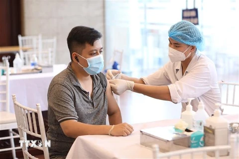 Nhân viên y tế tiêm vaccine phòng COVID-19 cho người dân quận Hoàn Kiếm, chiều 15/9. (Ảnh: Minh Quyết/TTXVN)