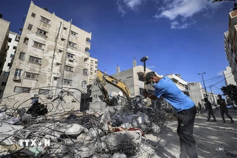 Người dân dọn dẹp đống đổ nát của những tòa nhà bị phá hủy sau các cuộc xung đột giữa Israel và phong trào Hồi giáo Hamas tại Dải Gaza ngày 5/6/2021. (Ảnh: AFP/TTXVN)