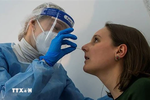 Nhân viên y tế lấy mẫu xét nghiệm COVID-19 cho người dân tại điểm xét nghiệm ở Berlin, Đức ngày 17/2/2021. (Ảnh: AFP/TTXVN)