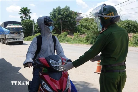 Người từ các tỉnh phía Nam đi xe mô tô về quê được Công an thành phố Đà Nẵng hướng dẫn, đảm bảo an toàn khi đi qua địa bàn thành phố. (Ảnh: Quốc Dũng/TTXVN)