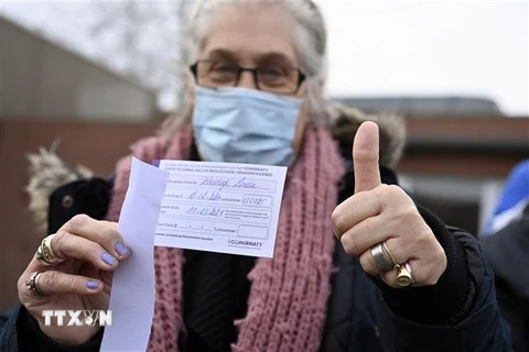 Một người dân nhận giấy Chứng nhận tiêm vaccine ngừa COVID-19 tại Overijse, Bỉ ngày 18/2/2021. (Ảnh: AFP/TTXVN)