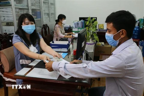 Người lao động nhận tiền hỗ trợ tại Bảo hiểm xã hội tỉnh Bạc Liêu. (Ảnh: Tuấn Kiệt/TTXVN)