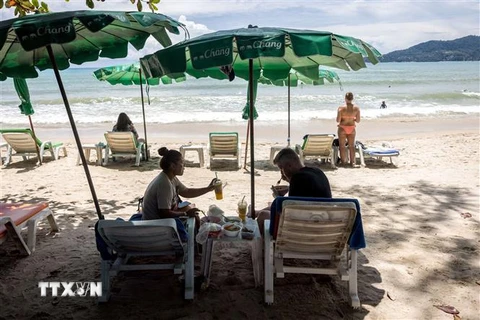 Du khách trên bãi biển ở Phuket, Thái Lan, ngày 14/8/2021. (Ảnh: AFP/TTXVN)