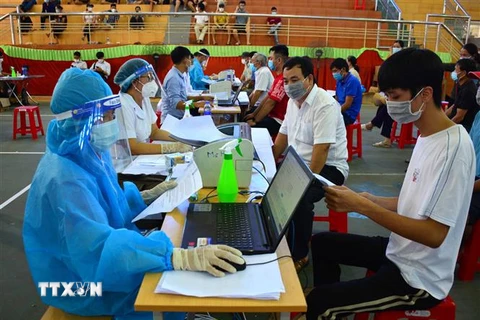 Bàn đăng ký, khai báo y tế cho người dân trước khi tiêm phòng COVID-19 tại nhà thi đấu huyện Hải Hậu, Nam Định. (Ảnh: Công Luật/TTXVN)
