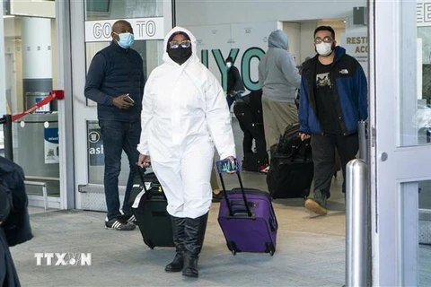 Hành khách đeo khẩu trang phòng lây nhiễm COVID-19 tại sân bay quốc tế JFK ở New York, Mỹ, ngày 22/12/2020. (Ảnh: AFP/TTXVN)