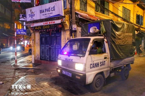 Lực lượng công an phường đi kiểm tra, nhắc nhở các hàng quán tại phố Tạ Hiện, quận Hoàn Kiếm. (Ảnh: Tuấn Đức/TTXVN)