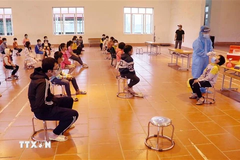 Nhân viên tế Phú Thọ tổ chức lấy mẫu xét nghiệm lần 3 cho học sinh Trường tiểu học Bạch Hạc. (Ảnh: Trung Kiên/TTXVN)