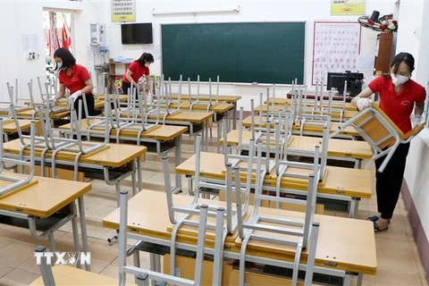 Các cô giáo và nhân viên Trường tiểu học Gia Cẩm (thành phố Việt Trì) vệ sinh lớp học, sẵn sàng đón học sinh trở lại. (Ảnh: Trung Kiên/TTXVN)