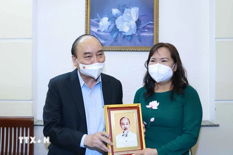 Chủ tịch nước Nguyễn Xuân Phúc thăm tặng quà cho thạc sỹ nhà giáo Triệu Thị Huệ, sinh năm 1965, sống tại phường 15, Quận 5, TP Hồ Chí Minh. (Ảnh: Thống Nhất/TTXVN)