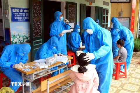 Lực lượng y tế lấy mẫu xét nghiệm cho toàn bộ học sinh trường Tiểu học Nguyên Xá (Thái Bình), nơi ghi nhận 6 học sinh dương tính với SARS- CoV-2. (Ảnh: Thế Duyệt/TTXVN)