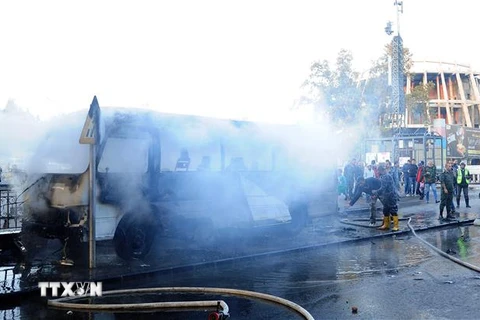 Lực lượng cứu hỏa dập lửa xe buýt chở các quân nhân Syria bị đánh bom ở Damascus, ngày 20/10. (Ảnh minh họa: AFP/TTXVN)