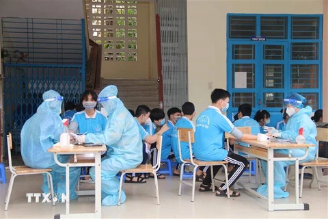 Học sinh được khám sàng lọc trước khi tiêm vaccine phòng COVID-19 tại điểm tiêm Trường THCS Lý Tự Trọng, thành phố Trà Vinh. (Ảnh minh họa: Thanh Hòa/TTXVN)