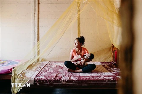 Người dân El Salvador mắc màn phòng muỗi gây bệnh sốt rét. (Ảnh: Compassion/TTXVN)