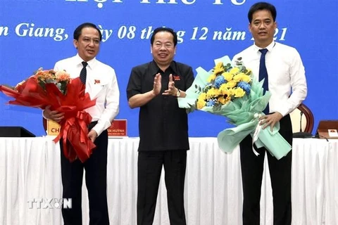 Ông Mai Văn Huỳnh (giữa), Chủ tịch HĐND tỉnh tặng hoa chúc mừng tân Phó Chủ tịch UBND tỉnh Lê Quốc Anh (phải). (Ảnh: Lê Sen/TTXVN)