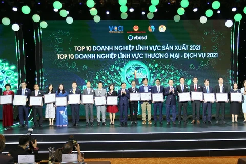 Đại diện Vinamilk (thứ 5 từ bên trái) cùng các doanh nghiệp trong Top các doanh nghiệp bền vững nhất Việt Nam năm 2021 thuộc hai lĩnh vực: sản xuất và thương mại-dịch vụ. (Nguồn: Vietnam+)
