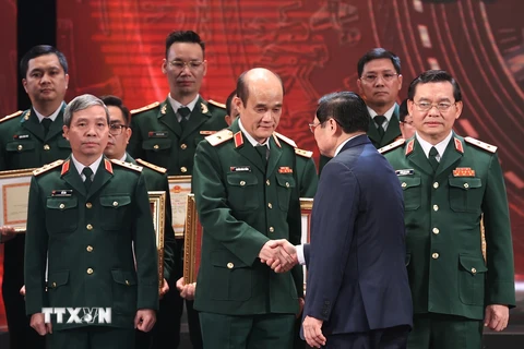 Thủ tướng Phạm Minh Chính trao Huân chương cho các tập thể có thành tích xuất sắc trong công tác phòng, chống dịch. (Ảnh: Dương Giang/TTXVN)