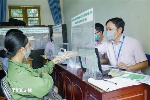 Cán bộ Ngân hàng chính sách xã hội giao dịch ở xã Thanh Luông, huyện Điện Biên. (Ảnh: Xuân Tư/TTXVN)