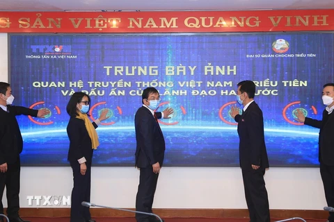 Phó Tổng giám đốc Thông tấn xã Việt Nam Nguyễn Tuấn Hùng và Tham tán, Đại biện lâm thời Đại sứ quán Cộng hòa dân chủ nhân dân Triều Tiên tại Việt Nam Ri Ho Jun cùng các đại biểu bấm nút khai mạc trưng bày ảnh. (Ảnh: Tuấn Anh/TTXVN)