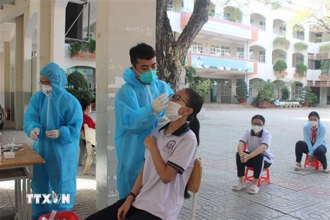 Học sinh trường Trần Nguyên Hãn, huyện Long Điền, Bà Rịa-Vũng Tàu được lấy mẫu xét nghiệm COVID-19 trước khi quay trở lại trường học trực tiếp. (Ảnh: Hoàng Nhị/TTXVN)