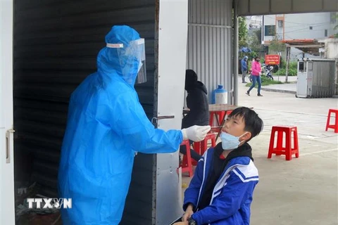 Nhân viên y tế tỉnh Thanh Hóa lấy mẫu xét nghiệm COVID-19 cho học sinh. (Ảnh: Nguyễn Nam/TTXVN)