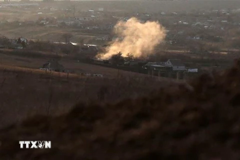 Khói bốc lên từ một vụ nổ do pháo kích tại làng Novohnativka, vùng Donetsk, gần khu vực đóng quân của quân đội Ukraine trong xung đột với lực lượng li khai ở miền Đông, ngày 19/2. (Ảnh: AFP/TTXVN)