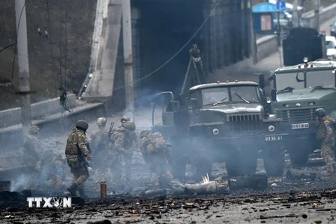 Binh sỹ Ukraine tìm kiếm đầu đạn chưa phát nổ sau giao tranh với lực lượng Nga tại thủ đô Kiev ngày 26/2. (Ảnh: AFP/TTXVN)