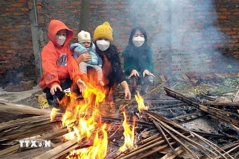 Người dân huyện Yên Lạc (Vĩnh Phúc) đốt lửa sưởi ấm trong tiết trời lạnh giá. (Ảnh: Hoàng Hùng/TTXVN)