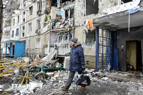 Người dân rời khỏi một tòa nhà đổ nát sau vụ pháo kích tại thành phố Kharkiv, Ukraine, ngày 8/3. (Ảnh: AFP/TTXVN)