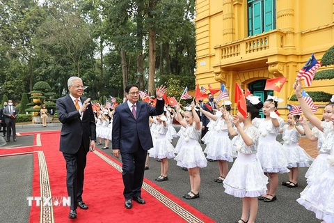 Thiếu nhi Thủ đô Hà Nội chào đón Thủ tướng Phạm Minh Chính và Thủ tướng Malaysia Dato’ Sri Ismail Sabri bin Yaakob. (Ảnh: Dương Giang/TTXVN)