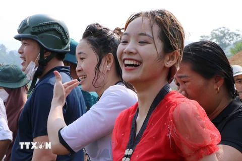 Một cô gái Thái vui vẻ dù bị ướt. (Ảnh: Nguyễn Oanh/TTXVN)