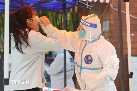 Nhân viên y tế lấy mẫu xét nghiệm COVID-19 cho người dân tại Thượng Hải, Trung Quốc, ngày 4/4. (Ảnh: THX/TTXVN)