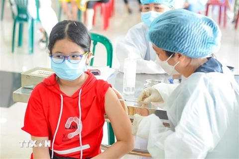 Nhân viên y tế tiêm vaccine cho các em học sinh. (Ảnh: Văn Dũng/TTXVN)