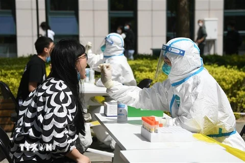 Nhân viên y tế lấy mẫu xét nghiệm COVID-19 cho người dân tại Bắc Kinh, Trung Quốc ngày 26/4. (Ảnh: THX/TTXVN)