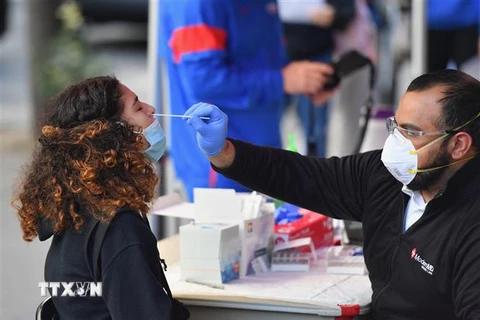 Nhân viên y tế lấy mẫu xét nghiệm COVID-19 cho người dân tại New York, Mỹ. (Ảnh: AFP/TTXVN)