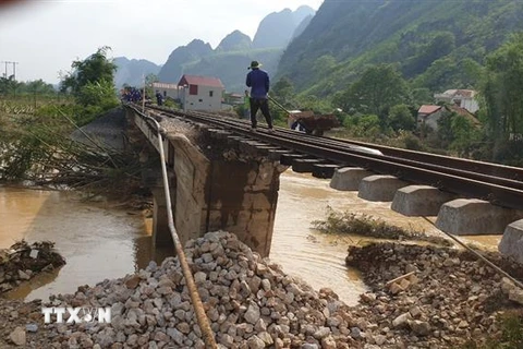 Nền đường sắt bị nước lũ xói mạnh sâu chỉ còn ray và tà vẹt trên tuyến đường sắt Hà Nội-Lạng Sơn ngày 11/5. (Ảnh: TTXVN phát)