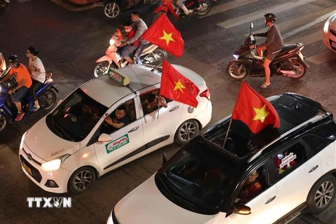 Người dân đổ ra đường ăn mừng chiến thắng của U23 Việt Nam. (Ảnh: Thanh Tùng/TTXVN)