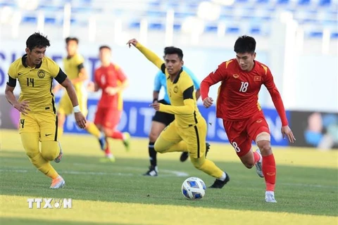 Tiền đạo Nhâm Mạnh Dũng đi bóng qua hàng phòng ngự U23 Malaysia. (Ảnh: Song Ngọc/TTXVN phát)