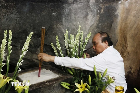 Chủ tịch nước Nguyễn Xuân Phúc dâng hương tại Hang 8 thanh niên xung phong nhân kỷ niệm 50 năm Ngày hy sinh các liệt sỹ Thanh niên xung phong tại đường 20 Quyết Thắng. (Ảnh: Thống Nhất/TTXVN)